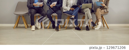 Legs of various people sitting in row in waiting room before interview or business meeting. 129671206