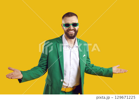 Funny man in green suit and sunglasses spreads arms and welcomes you to St Patrick's Day party 129671225