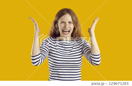 Portrait of crying emotional young woman who is screaming feeling angry and furious. 129671263