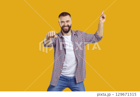 Happy excited magnificent bearded man 30s years old wears plade shirt pointing finger up on workspace area. Happy excited magnificent bearded man 30s years old wears plade shirt pointing finger up on workspace area. 129671315