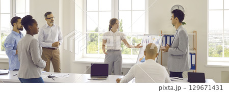 Colleagues near whiteboard with graphs in office discussing results of marketing research. 129671431