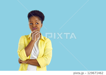 Happy, beautiful, young african-american woman in white T-shirt and yellow shirt on an isolated blue background. 129671462
