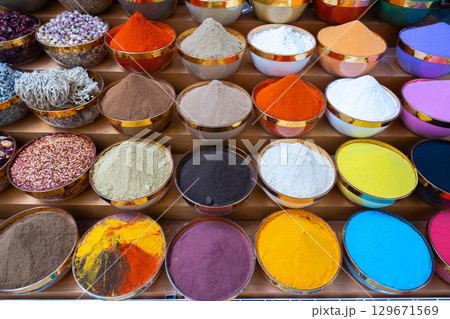 Traditional spices market. Pots and wooden tubs stand in row with colorful tea, spices, fruits, roots, flowers. Street bazaar. Dubai, UAE. Top view Traditional spices market. Pots and wooden tubs stand in row with colorful tea, spices, fruits, roots, flowers. Street bazaar. Dubai, UAE. Top view 129671569