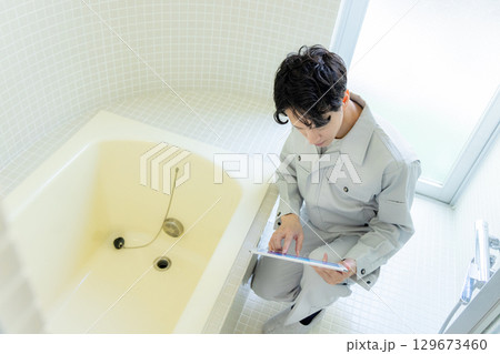 バスルームの点検をする男性作業員 バスルームの点検をする男性作業員 129673460