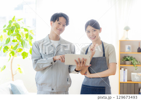 リフォームの打ち合わせをする作業着を着た男女 129673493