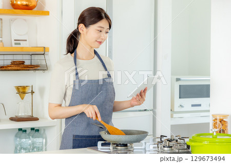 キッチンに立つ女性　タブレット 129673494
