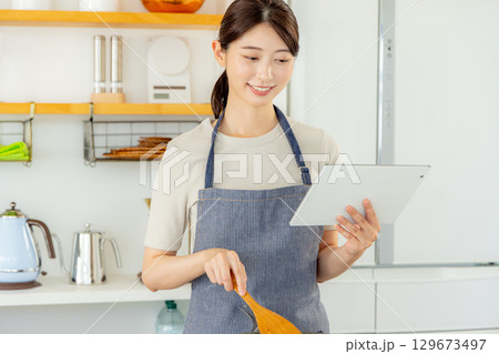 キッチンに立つ女性 タブレット キッチンに立つ女性 タブレット 129673497