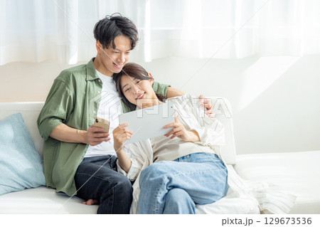 夫婦　ソファ　くつろぐ 129673536