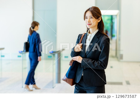 オフィスのロビーを歩くスーツ姿の若い女性 129673587