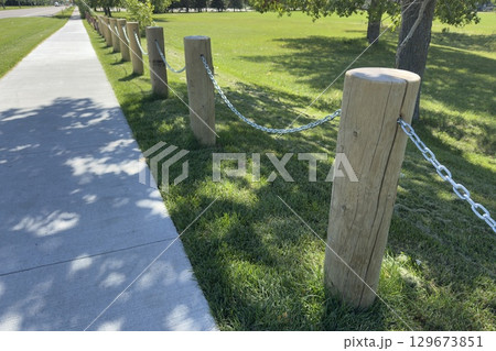 Wooden fence posts with metal chain Wooden fence posts with metal chain 129673851
