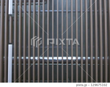 空調ダクトを覆う木製ルーバーの天井 129675102