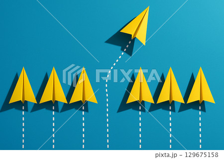 A row of yellow airplanes led by a yellow leader airplanes in a line as leadership in alignment 129675158