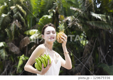 パイナップルとバナナを持つ女性 パイナップルとバナナを持つ女性 129675556