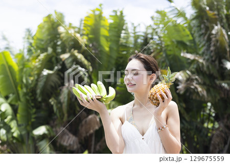パイナップルとバナナを持つ女性 129675559