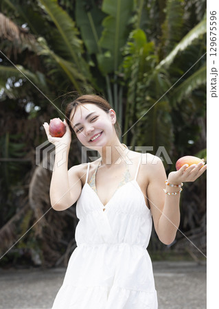 マンゴーを持つ綺麗な女性 129675596