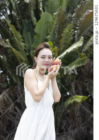 マンゴーを持つ綺麗な女性 129675601