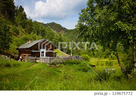 An old country house in the middle of a forest and mountains  129675772