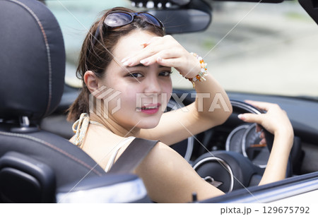 車を運転するかわいい女性 129675792