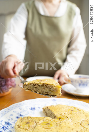 ケーキを焼いて紅茶を入れ自分時間を楽しむシニア女性　顔無し 129675954