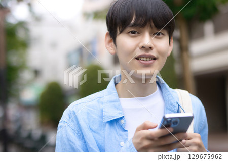 街中を歩く若い男性 129675962