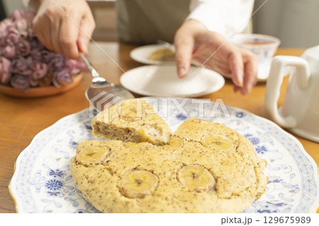 バナナと紅茶のケーキをケーキサーバーで取り分ける 129675989