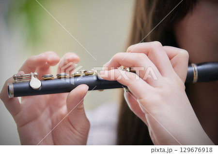 ピッコロを吹く若い女性 129676918