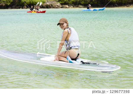 SUPを楽しむかわいい女性 129677398