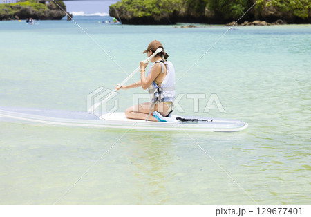 SUPを楽しむかわいい女性 129677401