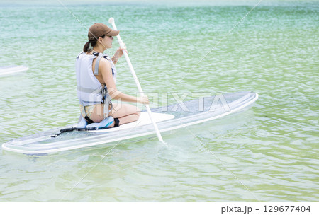 SUPを楽しむかわいい女性 129677404