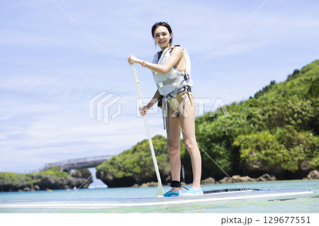 SUPを楽しむかわいい女性 129677551