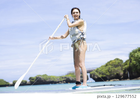 SUPを楽しむかわいい女性 129677552