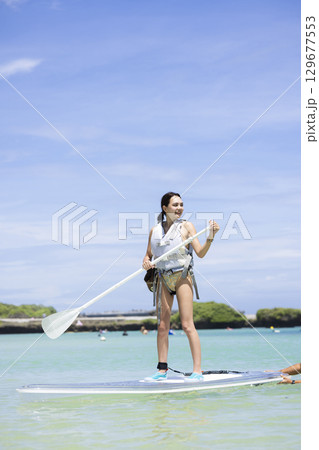 SUPを楽しむかわいい女性 129677553