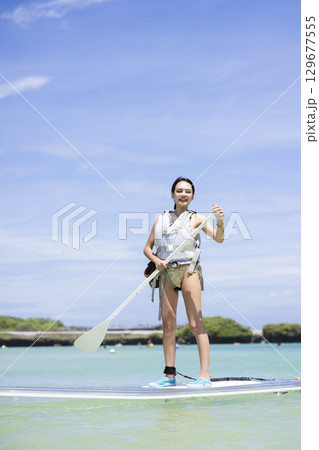 SUPを楽しむかわいい女性 129677555