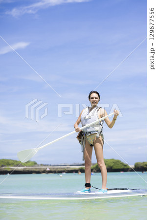SUPを楽しむかわいい女性 129677556