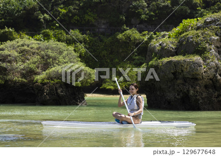 SUPを楽しむかわいい女性 129677648