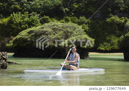 SUPを楽しむかわいい女性 129677649