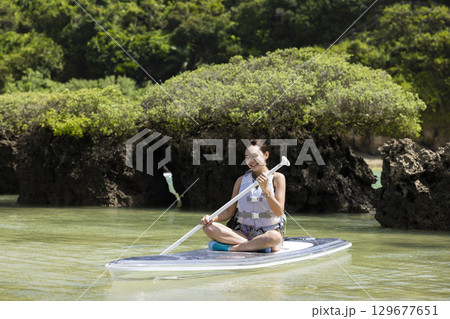 SUPを楽しむかわいい女性 129677651
