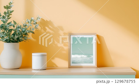 Modern Interior Display with Ocean Artwork, Vase, and Candle on Yellow Wall Background 129678755