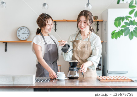 カフェ・コーヒーショップ・喫茶店でコーヒーを淹れるバリスタ・焙煎士の女性スタッフ・マスター カフェ・コーヒーショップ・喫茶店でコーヒーを淹れるバリスタ・焙煎士の女性スタッフ・マスター 129679759