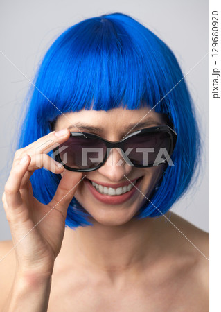 Close up beautiful woman with blue wig and sunglasses portrait 129680920