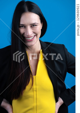 Woman with dark hair and yellow dress studio portrait 129680921