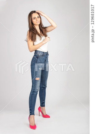 Studio fashion portrait of model with jeans and white blouse Studio fashion portrait of model with jeans and white blouse 129681017