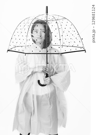 Asian woman with raincoat and transparent umbrella Asian woman with raincoat and transparent umbrella 129681124