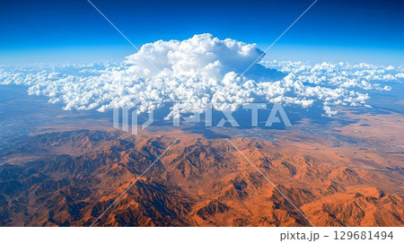 Aerial View of Immense Cumulus Cloud Over Desert Mountains 129681494