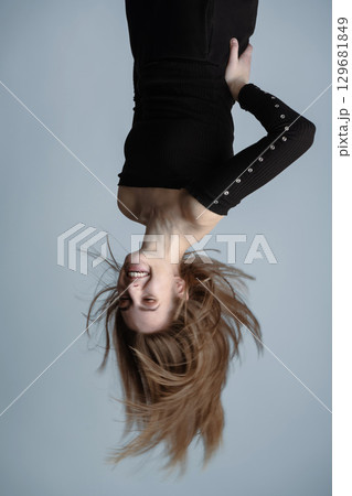 Woman hanging upside down portrait Woman hanging upside down portrait 129681849