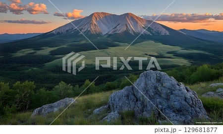 Majestic Mountain Range at Sunset with Lush Valley and Rocky Out 129681877