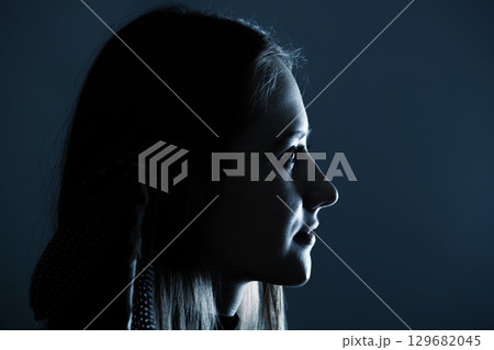 Low light side view of woman studio portrait Low light side view of woman studio portrait 129682045