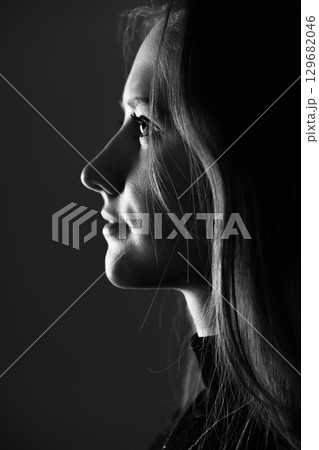 Low light side view of woman studio portrait Low light side view of woman studio portrait 129682046