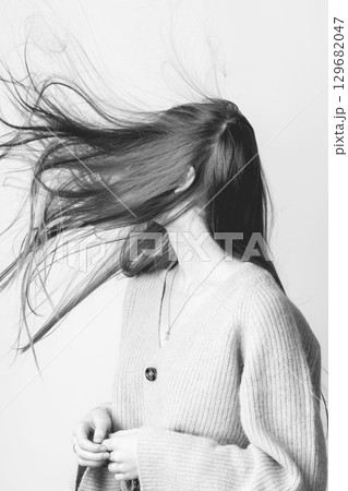 Wind blowing woman hair in bright studio background 129682047