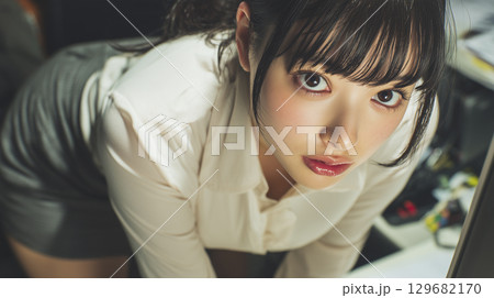 床に落ちたペンを拾う女性 129682170